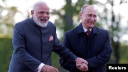Russian President Vladimir Putin (right) and Indian Prime Minister Narendra Modi react while walking near the Constantine Palace during their meeting in St. Petersburg in June 2017.