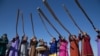 Музыканты коренного народа нивхов в традиционных костюмах, играют на трубах "Калны" во время церемонии встречи олимпийского огня в аэропорту Южно-Сахалинск на Тихоокеанском острове Сахалин, Россия, 14 ноября 2013 г.