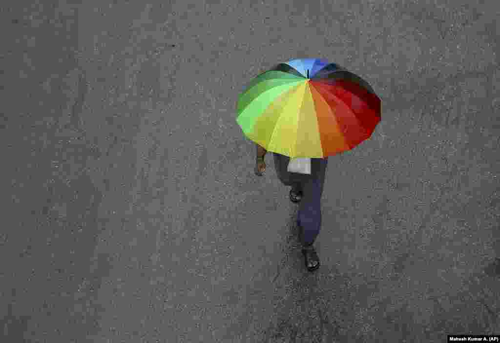 An Indian man walks with an umbrella during a rainstorm in Hyderabad on August 1. (AP/Mahesh Kumar A)