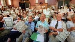 A crowd of French “debtors” in a Paris courtroom in 2001 display Russian government bonds purchased before the Bolshevik Revolution.