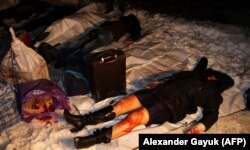 Тіла пасажирів рейсового автобусу, які були вбиті внаслідок ракетного удару російських гібридних сил. Загинуло 12 (за іншими даними 13) людей, ще 18 були поранені. Донеччина, околиця міста Волновахи, 13 січня 2015 року