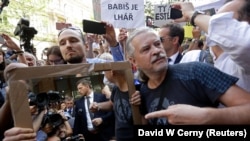 Участник акции протеста держит зеркало перед премьер-министром Андреем Бабишем во время его речи на мероприятии, приуроченном к годовщине подавления Пражской весны. Прага, 21 августа 2018 года.