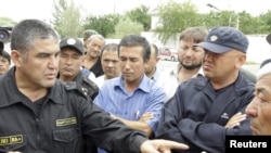 A Kyrgyz Interior Ministry officer talks to refugees on a street in the town of Osh in mid-June, about a week after the worst of the interethnic violence erupted in southern Kyrgyzstan.