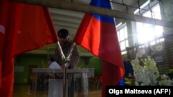 Мужчина опусает бюллетень в урну на избирательном участке в Санкт-Петербурге. 18 марта 2018 года.
