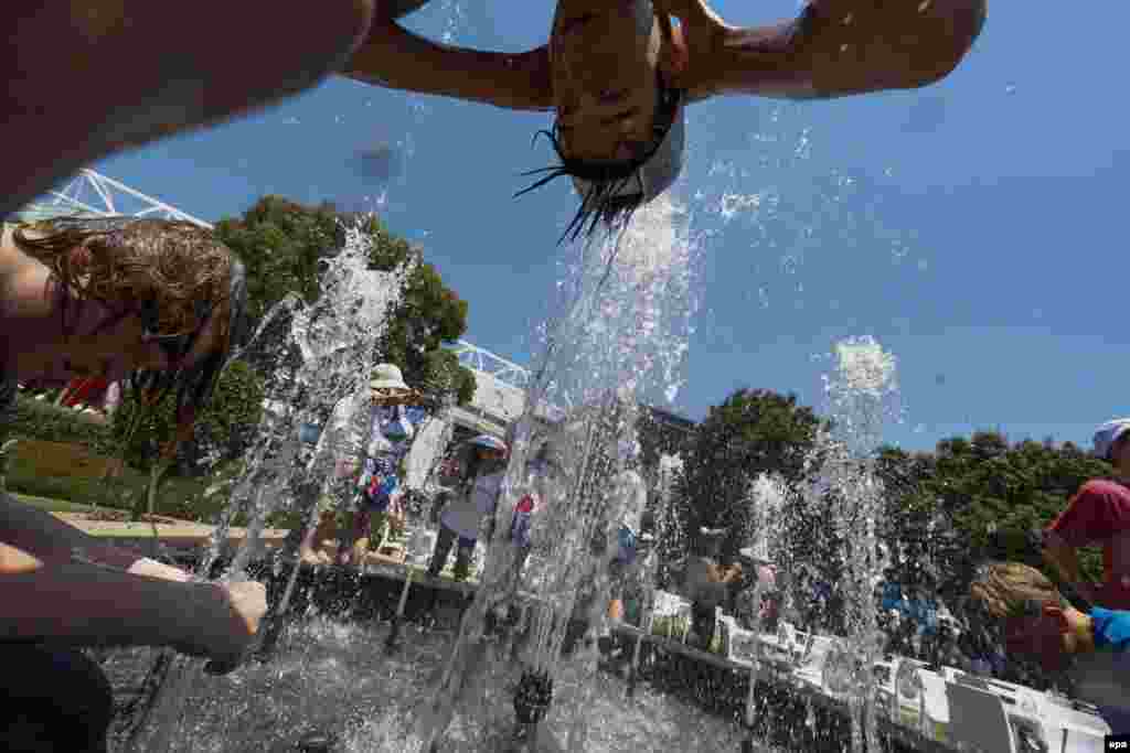 Tennis fans cool off in a fountain on January 16.