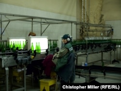 A worker inspects bottles at the Artwinery plant. Before the war, the winery had some 700 employees; now there are only about 250.