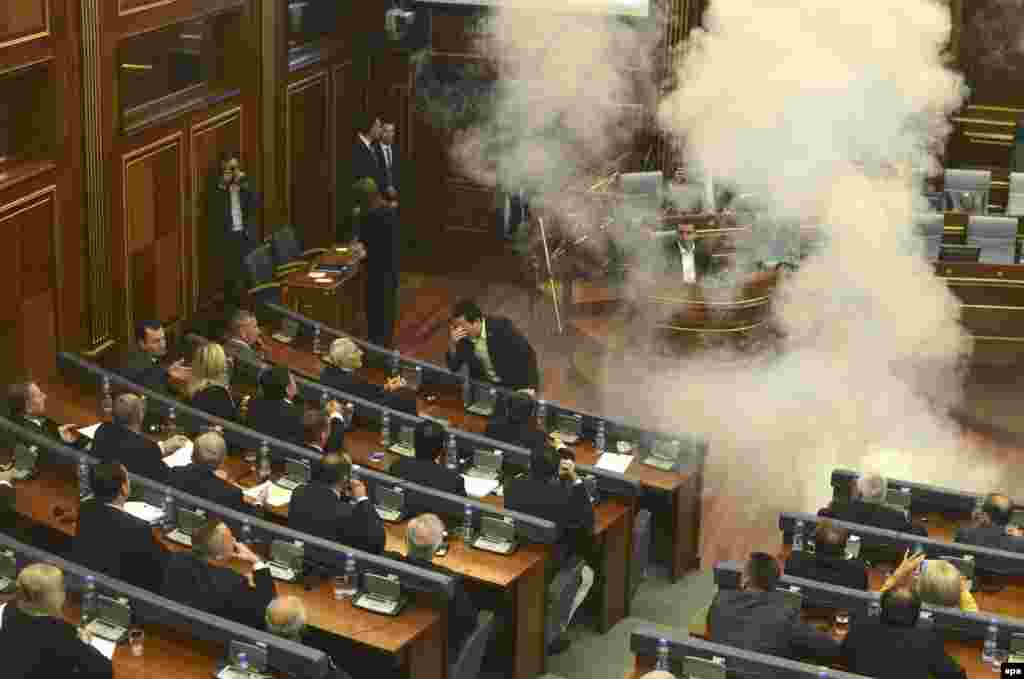 Opposition lawmakers throw tear gas during a session of Kosovo's parliament in Pristina on October 8. (epa/Petrit Prenaj)