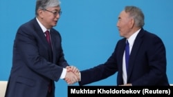 Вступивший в должность президента Касым-Жомарт Токаев (слева) пожимает руку бывшему президенту Нурсултану Назарбаеву в Нур-Султане. Апрель 2019 года.