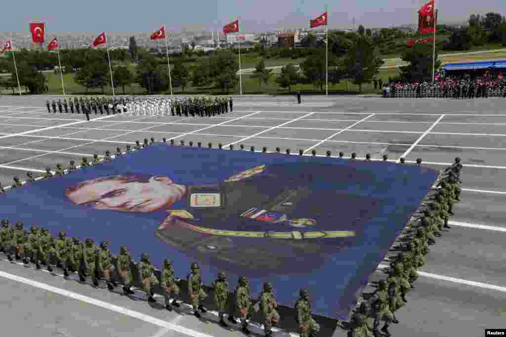 Turkish soldiers carry a banner bearing the portrait of Mustafa Kemal Ataturk, founder of modern Turkey, during a parade marking the 91st anniversary of Victory Day in Ankara. (Reuters/Umit Bektas)