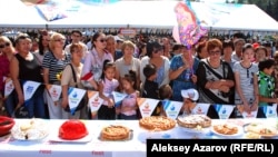 Группа людей смотрит на конкурсные пироги и ожидает решения жюри на праздничных мероприятиях ко Дню города. Алматы, 16 сентября 2012 года. 