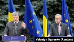 Ukrainian President Petro Poroshenko (left) and European Commission President Jean-Claude Juncker attend a joint news conference following the opening of the EU-Ukraine summit in Kyiv on July 13. 
