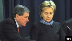 U.S. Secretary of State Hillary Clinton (right) talks with Ambassador Richard Holbrooke during a trilateral meeting with Afghan and Pakistan delegations at the State Department on February 26.