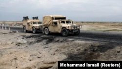 دو موتر نیروهای امنیتی افغان در حال عبور از ساحۀ در بگرام جایی‌که حمله انتحاری رخ داد و در اثر آن سه سرباز امریکایی کشته شدند، April 9, 2019