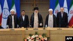 Former President Ali Akbar Hashemi Rafsanjani (second from right) stands next to Supreme Leader Ayatollah Ali Khamenei (center) at the opening session of the Nonaligned Movement summit in Tehran in August.