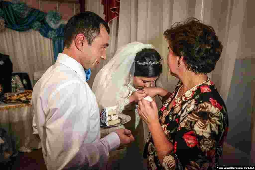 Пригостивши маму першим шматочком весільного торта, чоловіки, за старим звичаєм, цілують руку. Це знак поваги до старших