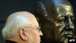 Mikhail Gorbachev stands next to a bust of himself after unveiling it in Berlin in November 2009.
