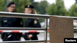 "Warum" (Zašto) piše na jednom kartonu na mestu ubistva civila ispred šoping centra "Olimpija", Minhen, 23. jul 2016.