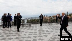 Президент США Дональд Трамп приветствует встречающих его людей на саммите «Большой семерки». Сицилия, 26 мая 2017 года. 