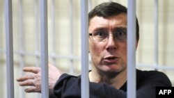 Former Ukrainian Interior Minister Yuriy Lutsenko gestures from a caged area during a court hearing in February. 