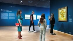 Ljudi gledaju Suncokrete Vincenta van Gogha u muzeju Van Gogh u Amsterdamu, Nizozemska, 1. juna 2020.