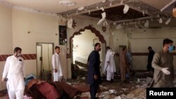 Members of a bomb-disposal unit survey the site after a blast at a mosque in Kuchlak, on the outskirts of Quetta, on August 16.