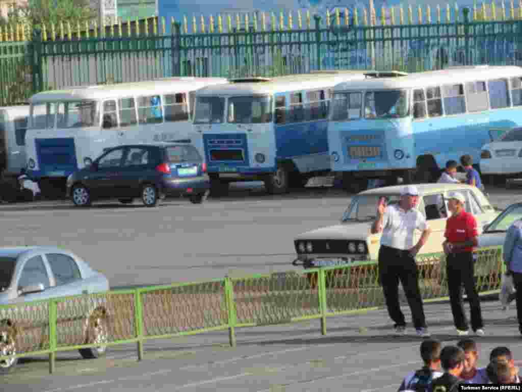 Buses used to transport those participating in Independence Day celebrations stand parked outside the Labor Stadium while rehearsals take place inside
