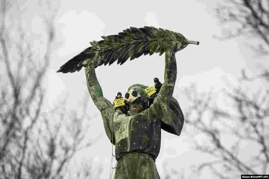 Environmental activists from Greenpeace demonstrate against the capital's air pollution on the Freedom Statue on top of Gellert Hill in Budapest. (AP/Balazs Mohai/MTI)