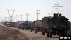 Turkish military vehicles drive toward the northern Syrian town of Al-Bab last month. 