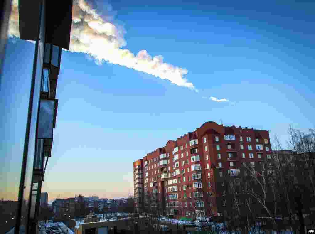 15 февраля недалеко от Челябинска взорвался небольшой астероид, известный как "челябинский метеорит". От ударной волны пострадало 1613 человек. На фото - конденсационный след в небе над городом.