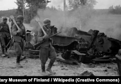 Битва під Іханталою. Фінські солдати, озброєні німецькими фаустпатронами, проходять повз знищений радянський танк, 1944 рік