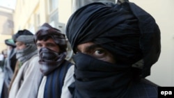 Former Taliban militants surrender their weapons during a reconciliation ceremony in Herat, August 3.