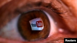 Логотип сайта YouTube отражается в радужке глаза человека.