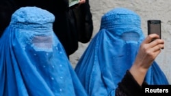 A burqa-clad woman takes photos with her mobile phone. (file photo)