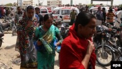 Relatives of victims arrive at the site of a deadly attack on a bus in Karachi that was carrying members of the Shi'a community. 