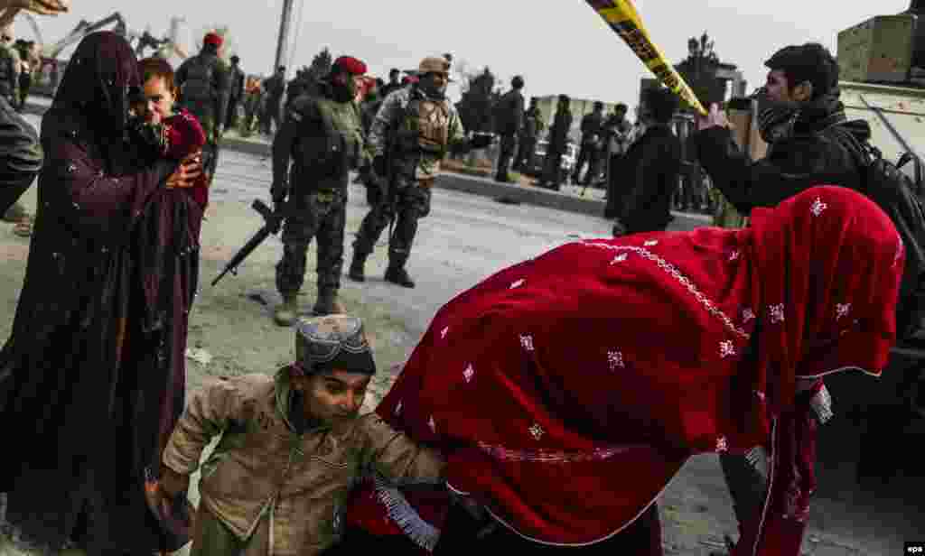 Owganystanyň paýtagty Kabulda adamlar janyndan geçen bombaçynyň amala aşyran hüjüminiň bolan ýerinden gaçýarlar. Şol hüjümde Ýewropa Bileleşiginiň polisiýa missiýasynyň ulagy nyşana alnypdy. 5-nji ýanwar, 2015 ý. (epa/Jawad Jalali).