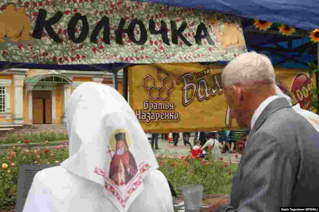 Покупательница меда в косынке с православной атрибутикой.