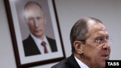 Mинистерот за надворешни работи на Русија, Сергеј Лавров и портрет на рускиот претседател Владимир Путин.