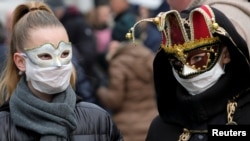 Туристи носят маски по време на карнавала във Венеция. Празненствата в неделя бяха отменени, след като властите потвърдиха над 100 заразени с коронавируса в Италия