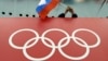 A Russian skating fan holds the country's national flag over the Olympic rings before the start of the men's 10,000-meter speed-skating race at the 2014 Winter Olympics in Sochi.