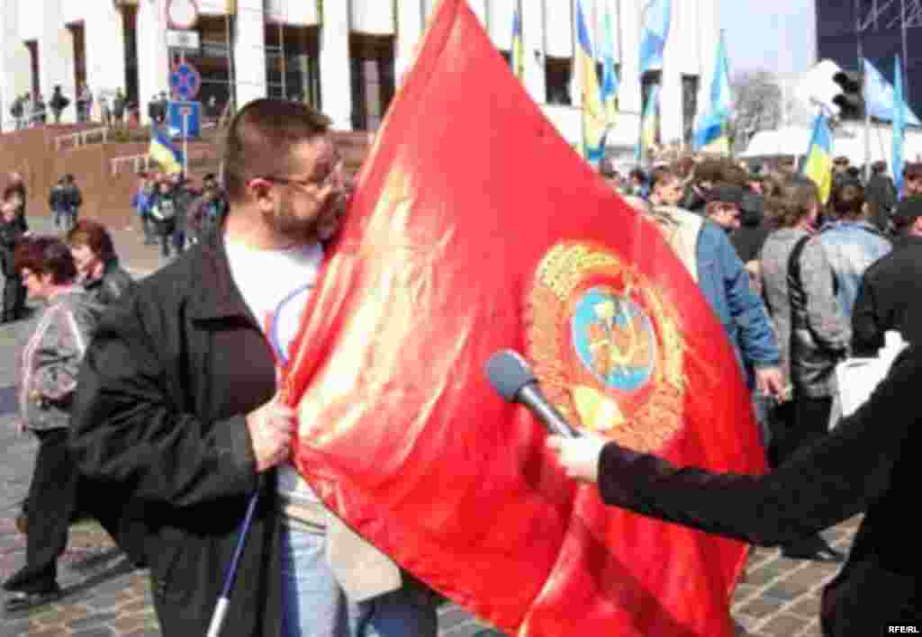 Nod To The Past - A coalition supporter holds a communist-era flag during the day's rallies. (photo: RFE/RL)