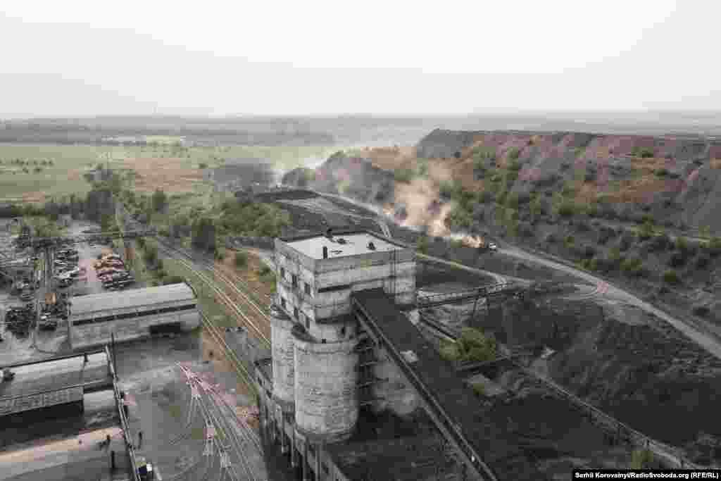 Вид на угольные бункеры, террикон с отработанной породой и цеха предприятия.