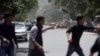 Afghans run from the site of a suicide attack in the center of Kabul on May 9, 