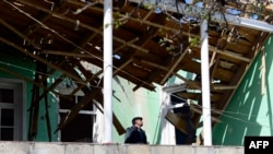 Nagorno-Karabakh -- A man looks at the roof of a house, which was damaged during clashes between Armenian and Azeri forces, in the village of Garagoyunlu, outside Terter, April 4, 2016