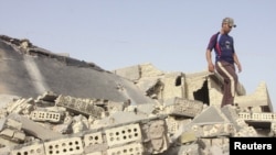 An Iraqi man inspects the site of a bomb attack at one of the homes of the police officers in Fallujah.