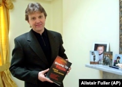 Aleksandr Litvinenko poses with his book Blowing Up Russia: Terror From Within at his home in London on May 10, 2002.