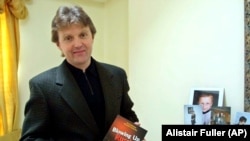 Aleksandr Litvinenko poses with his book, Blowing Up Russia: Terror From Within, at his home in London in May 2002.
