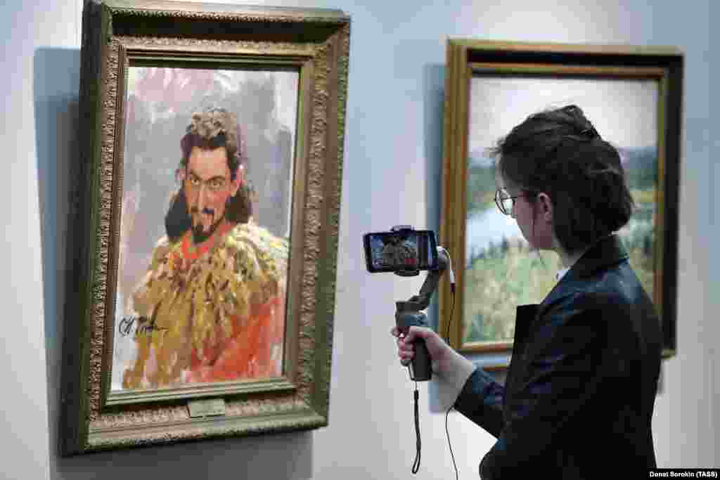 A woman livestreams an exhibition of works by Russian realist painter Ilya Repin in a Yekaterinburg museum on May 16.