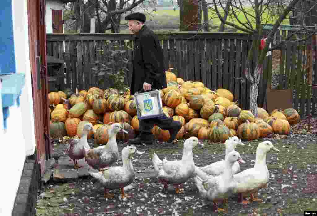 A member of a local election commission carries a ballot box to voters in the village of Vilshanska-Novoselytsa, some 75 km south of Kyiv.