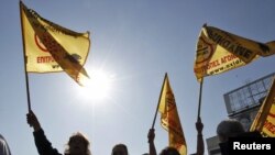 Greece -- Protesters wave flags outside the printing offices of Greek power utility PPC in Athens, 13Oct2011