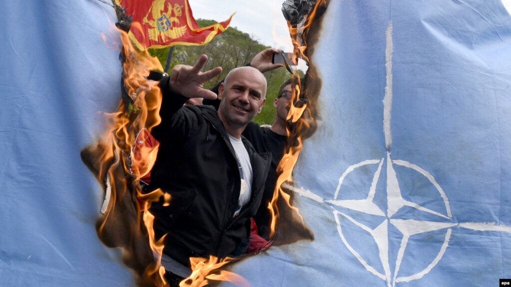 Protesters burn a NATO flag while Montenegro's parliament discusses the ratification of a NATO membership agreement in Cetinje in April.